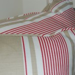 Close up photo of cushions in red and beige striped ticking fabric