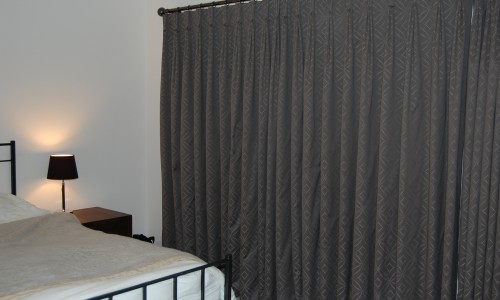 Photo showing a set of full length hand made curtains in a brown geometric fabric.